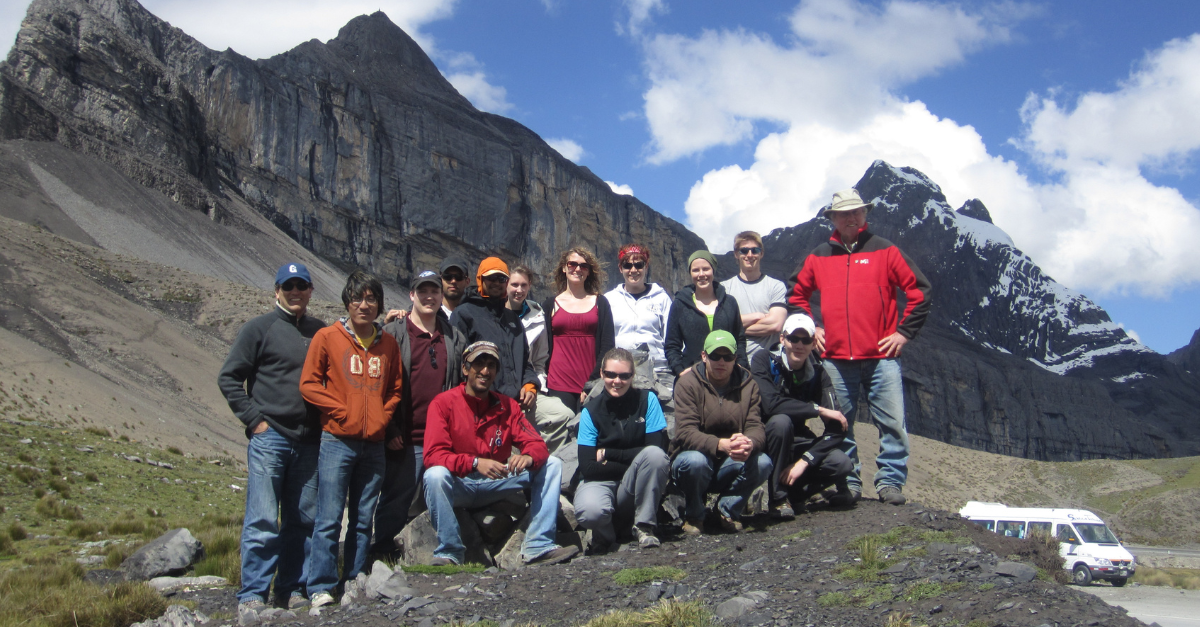 Stephen Evans and University of Waterloo students stand in front of a mountain peak. 
