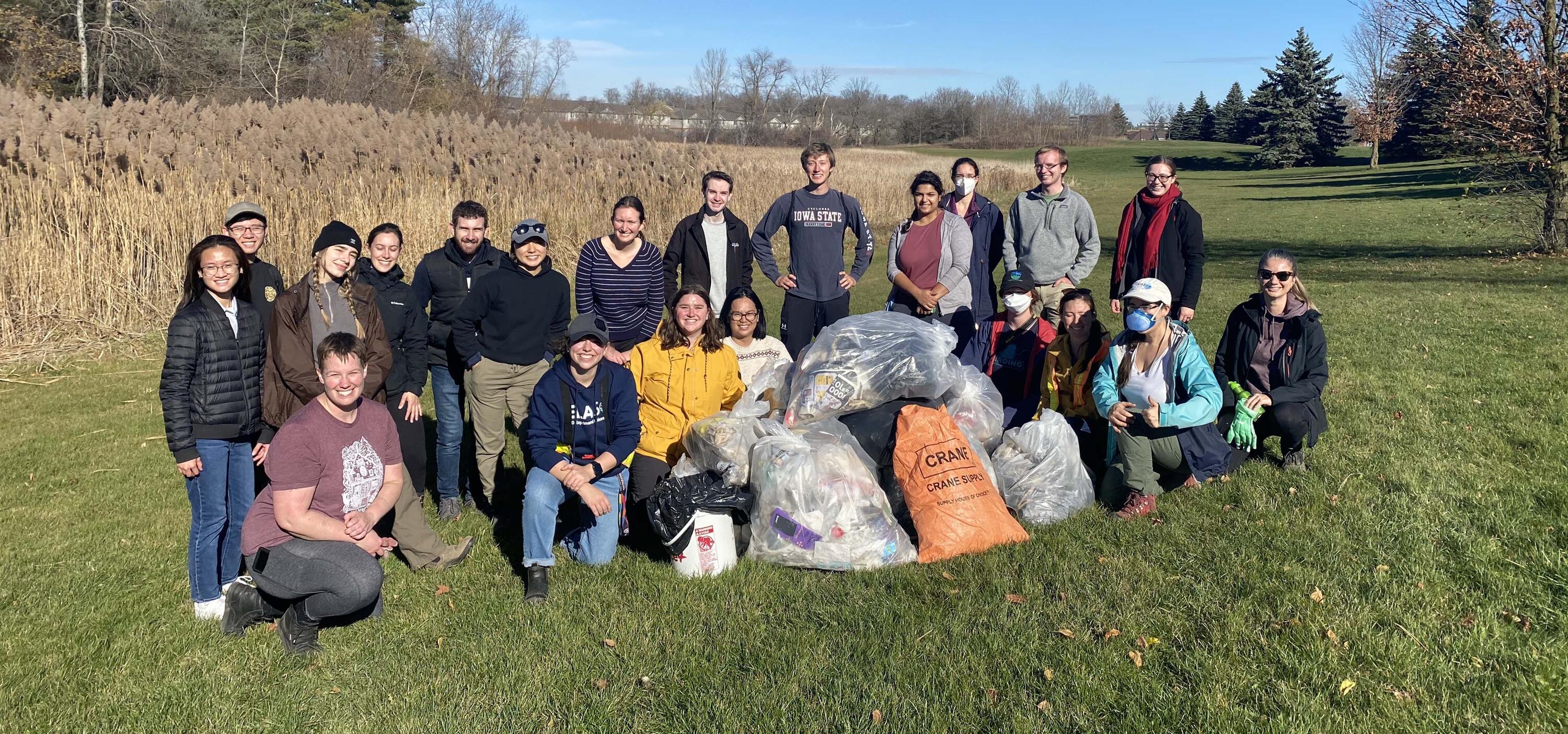 Group photo of participants with pile of bagged garbage.