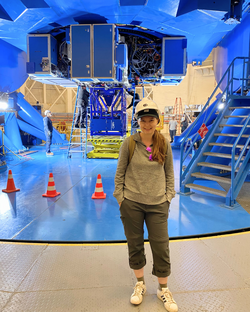Emily standing in front of the high-resolution optical spectrograph, GHOST.