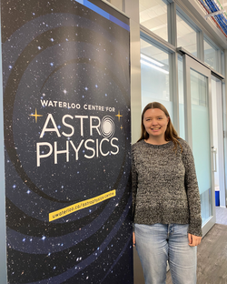 Emily standing next to the Waterloo Centre for Astrophysics pull up banner.