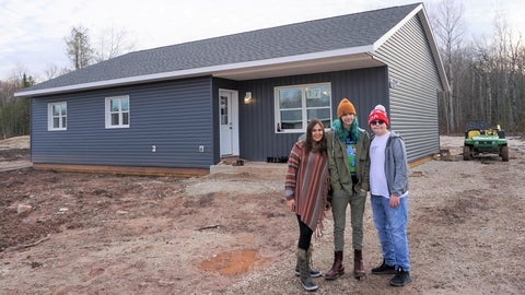 Family poses in front of their new net-zero energy house