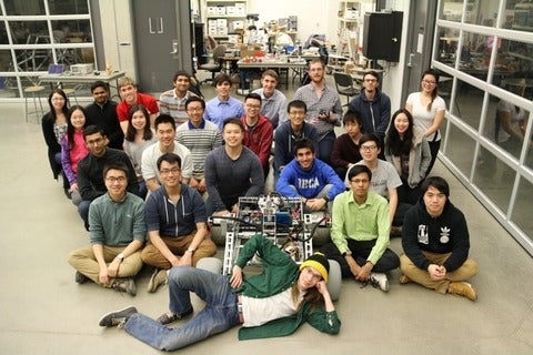 Photo of the whole Robotics team in front of their work bay in the SDC 