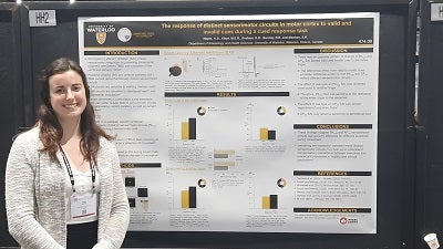 Kara Hayes next to their research poster presentation at the Society for Neuroscience annual meeting