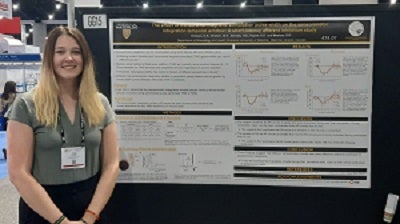 Kylee Graham standing next to their research poster presentation at the Society for Neuroscience Annual meeting