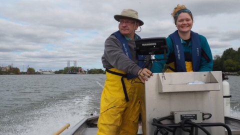 Professor Servos and his fellow researchers Hillary on a boat on a cloudy day