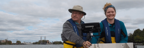 Professor Servos and his fellow researchers Hillary on a boat on a cloudy day