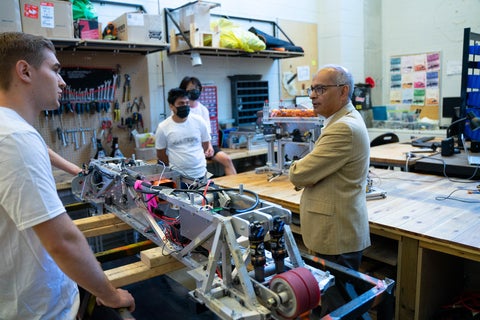 Vivek surrounded by students in a lab