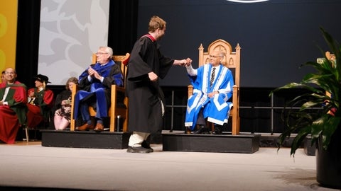 Vivek getting a fist bump on stage at convocation