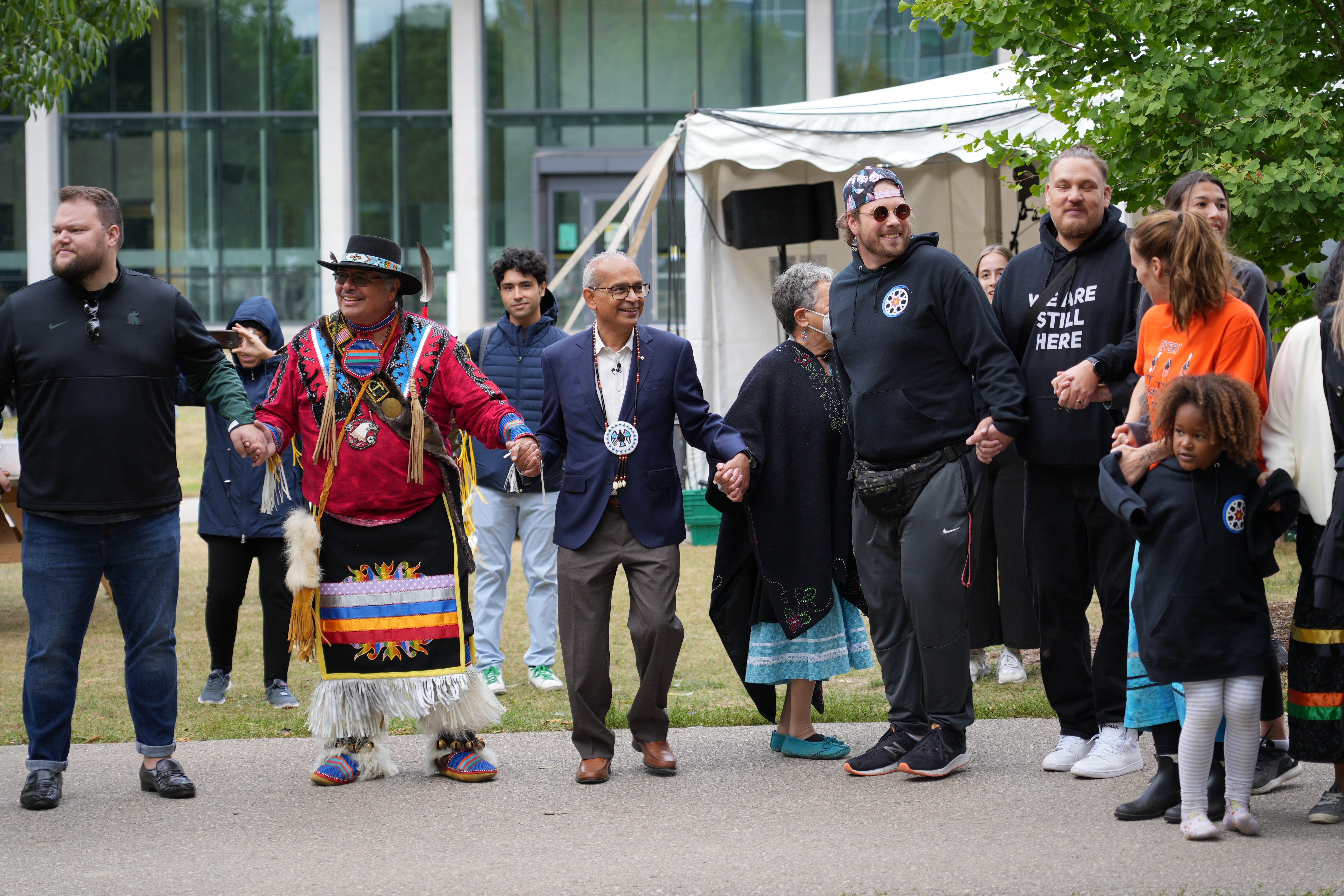 Vivek linking arms with Indigenous folks at an outdoor event
