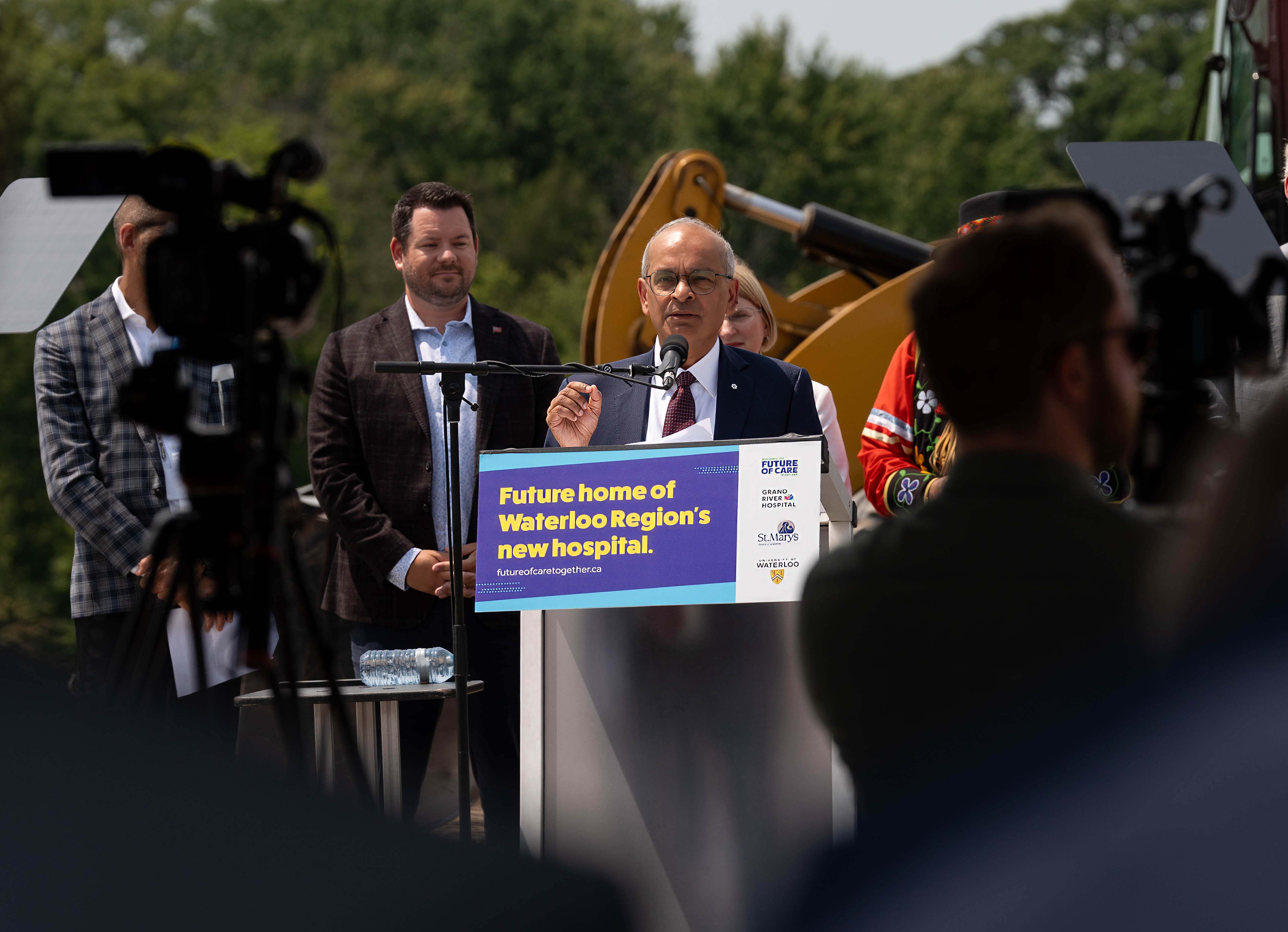 Vivek announcing the new hospital at a podium