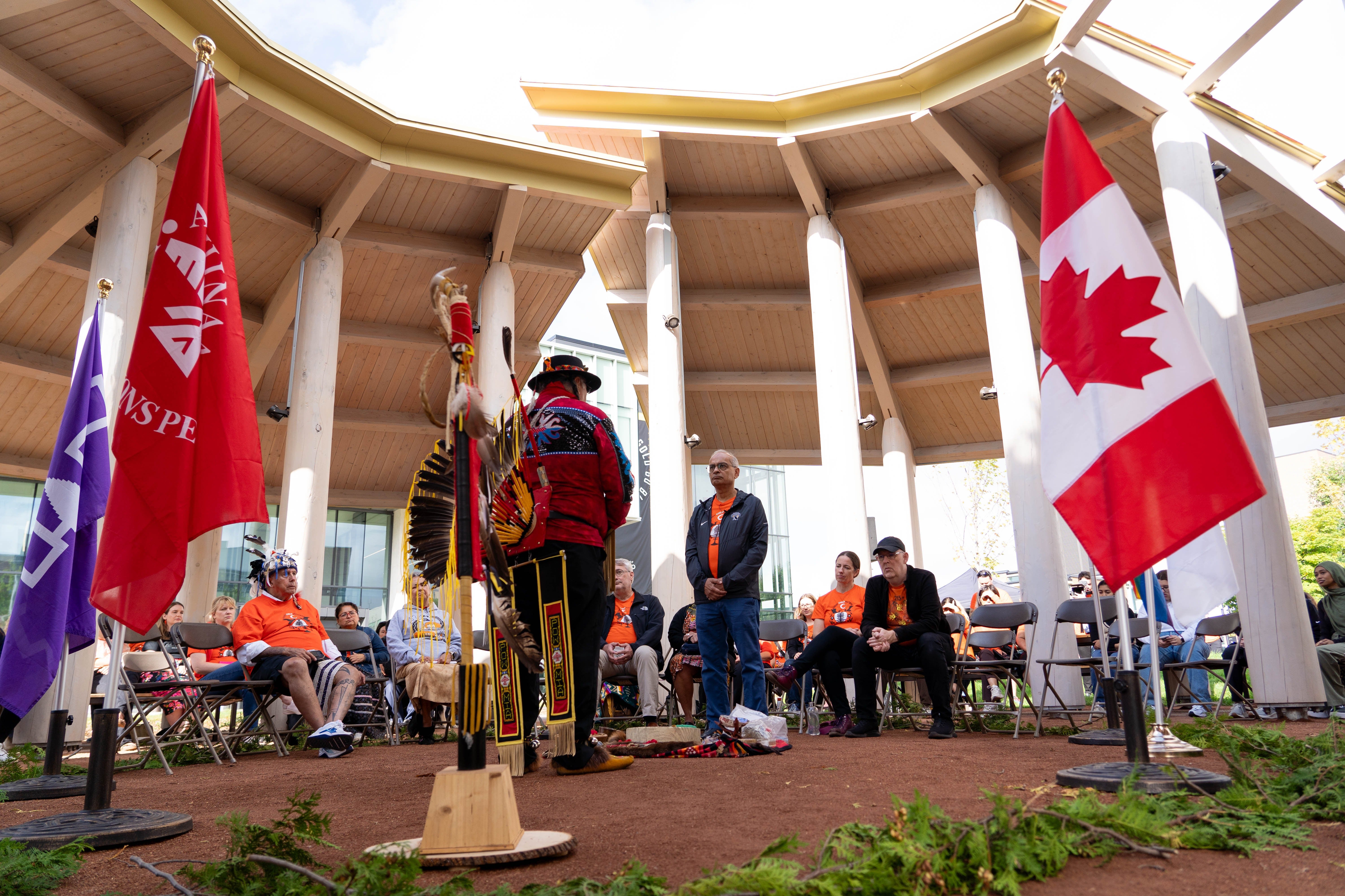 Vivek at the centre of an Indigenous gathering space listening to Elder henry