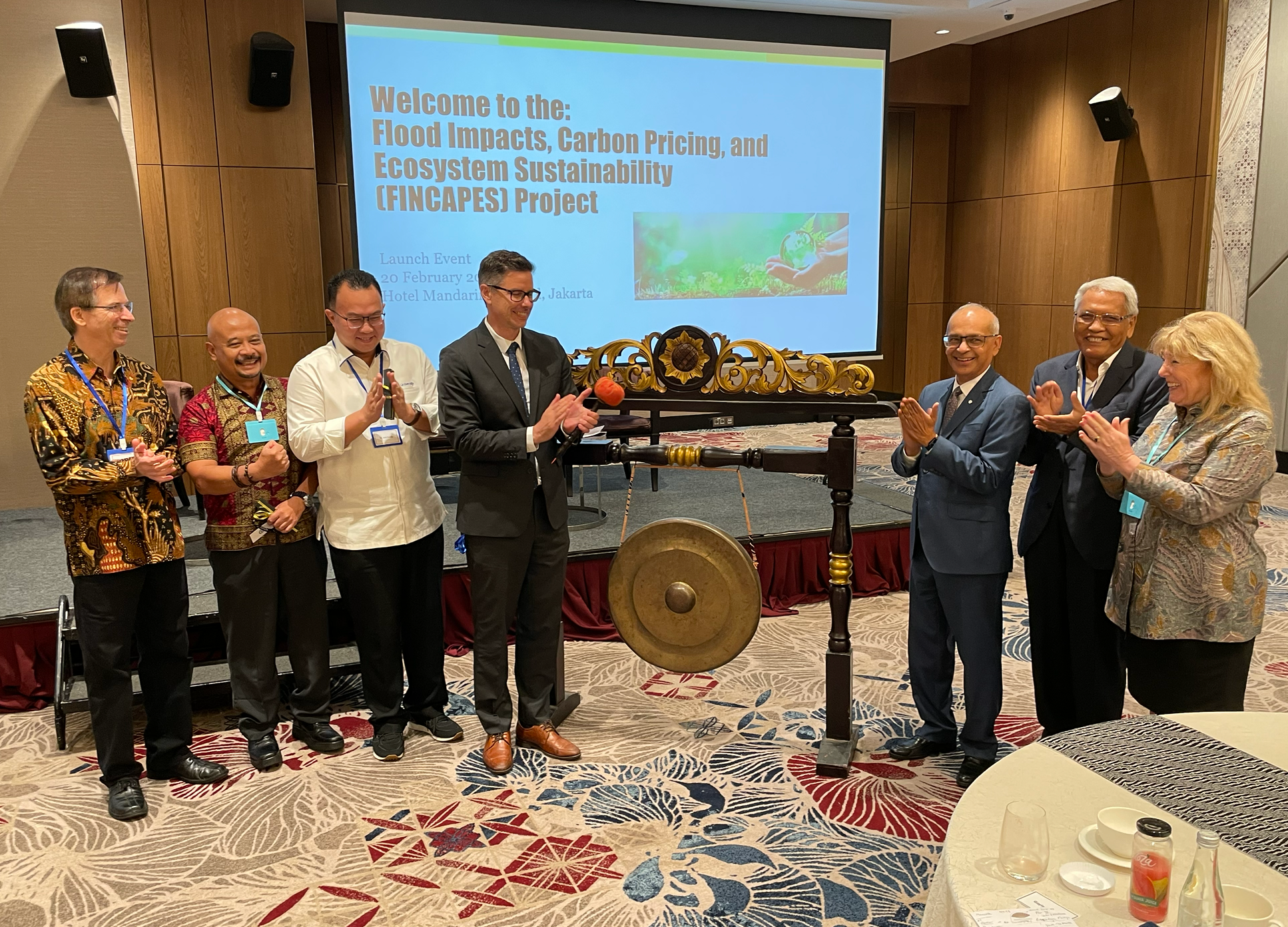 Vivek and some delegatres standing in front of a ceremonial gong