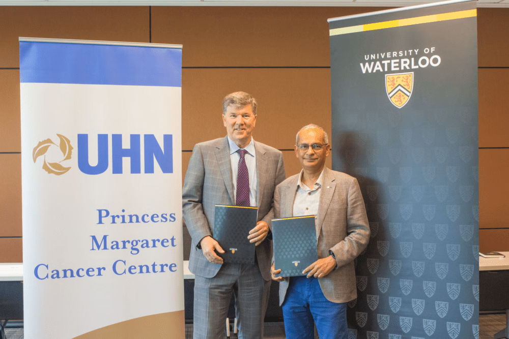 Vivek holding up a copy of Waterloo at 100 with a representative from Princess Margaret