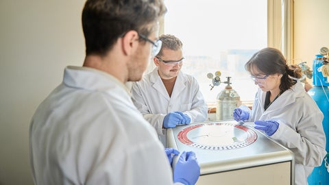 Three students in lab coats