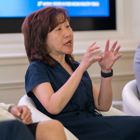 Jennifer Lee speaking on stage while sitting on a white chair with hands in motion 