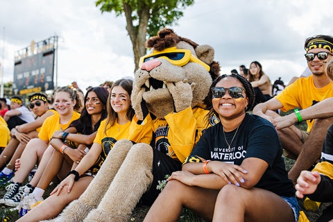 Students sitting with mascot King Warrior