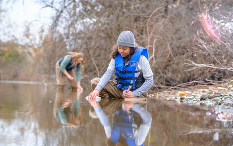 Student collecting sample from pond water