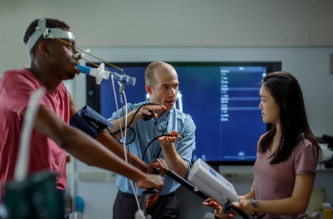 Professor teaching a student with VO2 max machine