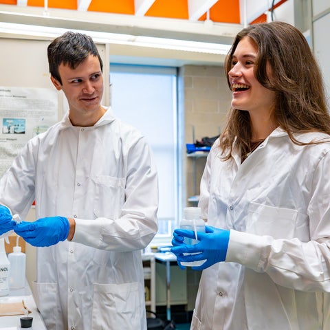 Two female scientist in a lab holding research equipment