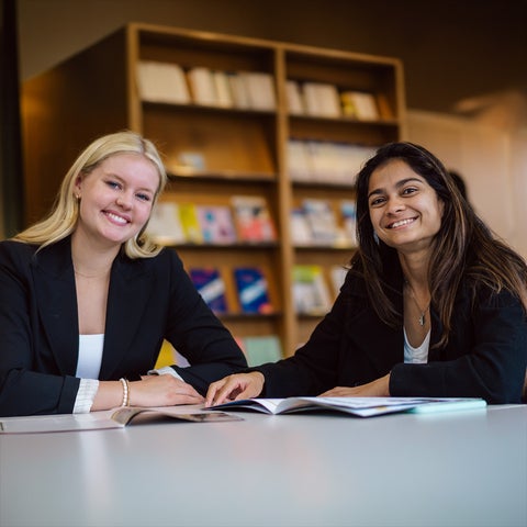 Two students in professional attire smiling