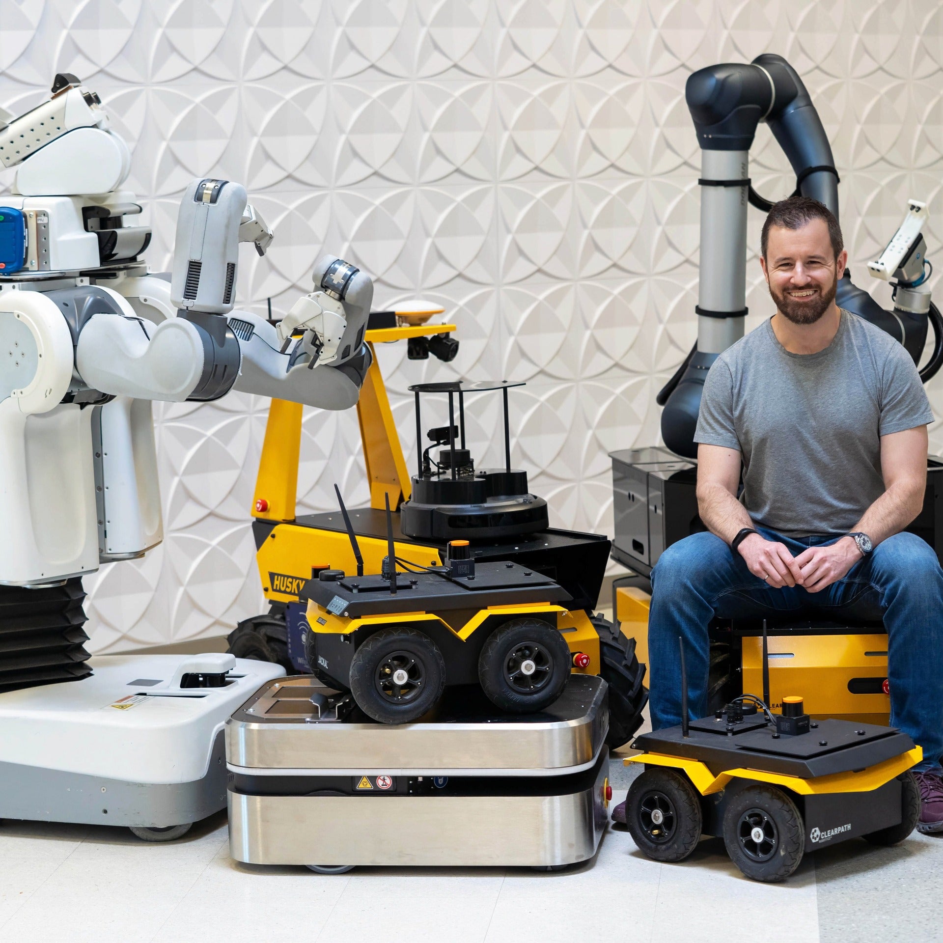 Ryan Gariepy sitting with Clearpath robotics and smiling