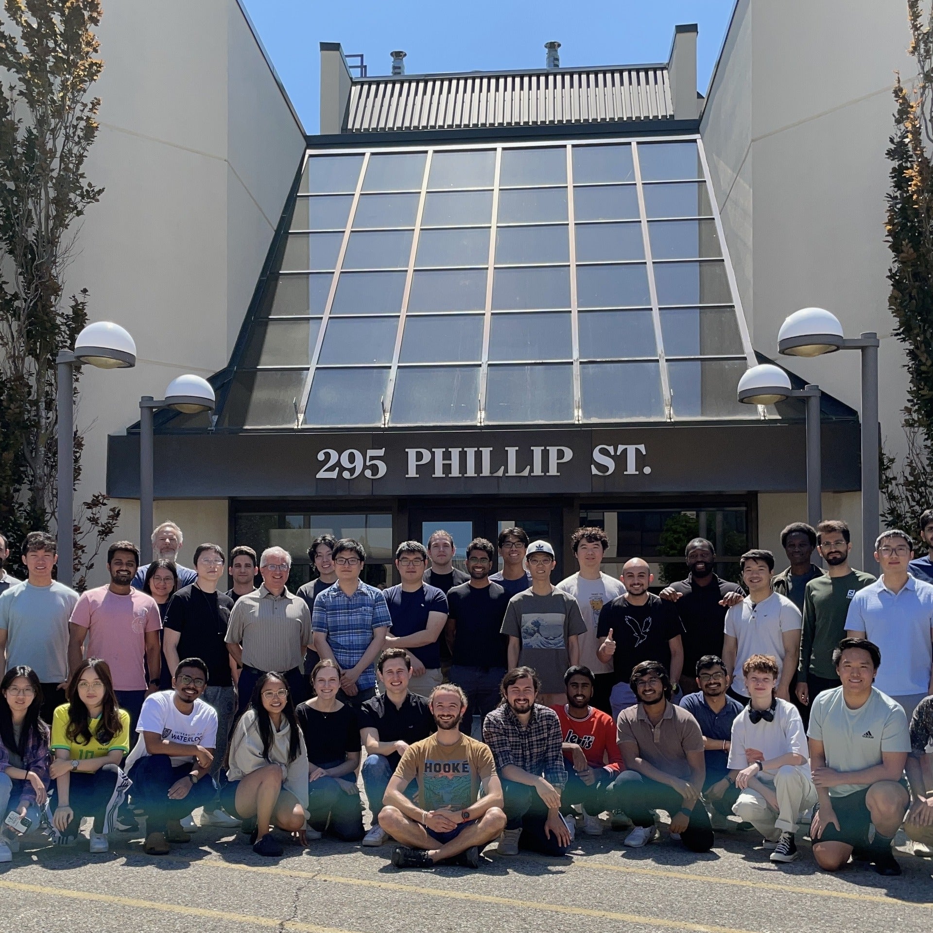 Group of University of Waterloo students huddled together in front of East Campus 4 building entrance