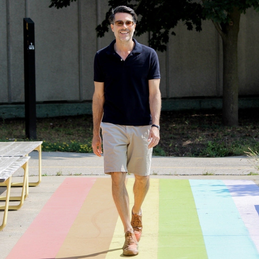 Dr. Brian Orend walking down the rainbow pathway in the Arts Quad