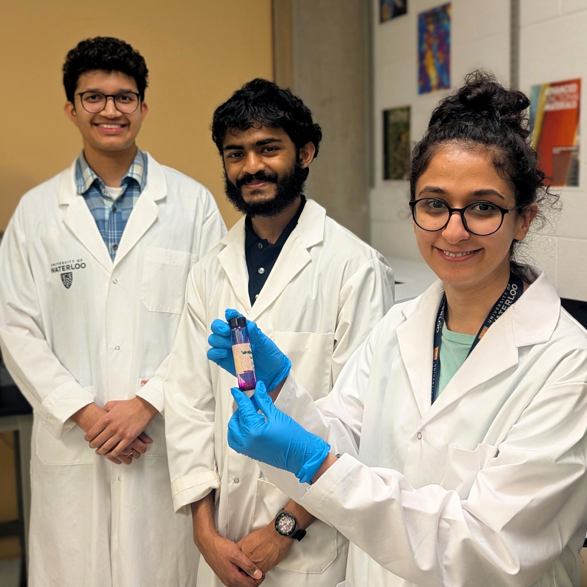 Waterloo students wearing lab coats and female student holding a vial of chemicals