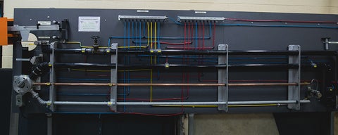 A wall with tubing of different colours and materials 