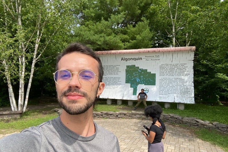 a person taking a selfie infront of a park sign
