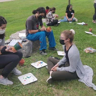 SWIGS members painting pots on green grass