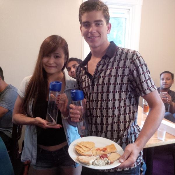 Two members with food and new water bottles at SWIGS event