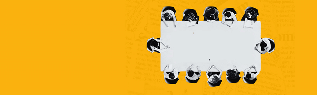 a group sitting around a board room table- seen from above