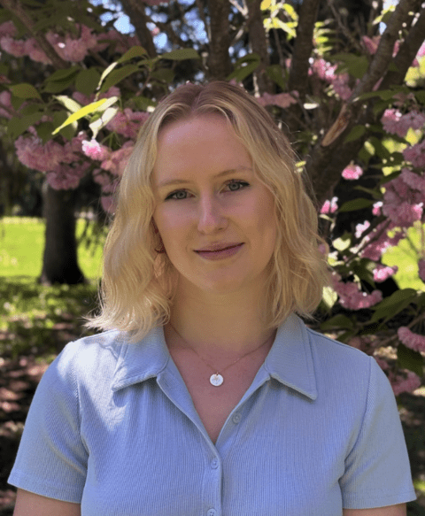 image of Kaitlyn Hunter standing in front of a blossoming tree