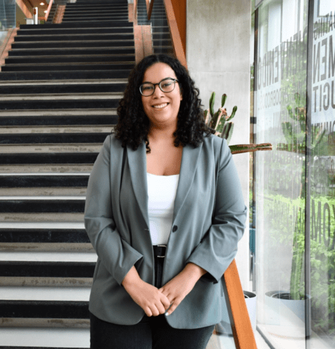 Image of Maria Brisbane standing in front of a staircase 