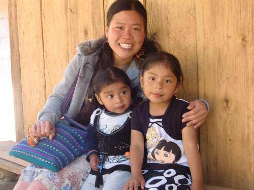 Faith Lee sitting with two Guatemalan children