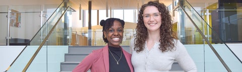 Hayley Winters and Kim Madume, St. Jerome's Advancement Team, smiling together in the St. Jerome's University Atrium