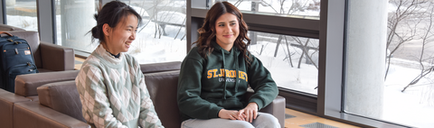 Students sitting in the chairs and talking together in the Siegfried Hall common lounge
