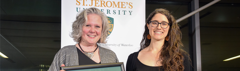 two women standing on stage accepting an award