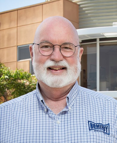 Fr. Gregory Boyle, SJ standing at the front entrance of his business, Homeboy Industries