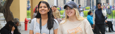 two students traveling in Peru smiling as they walk through the city centre