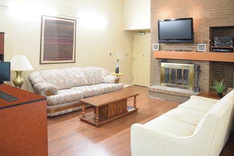 Common lounge area of Louis Hall Residence showing couches, tables, a TV and computer desk