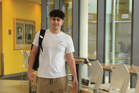 Mateo Racco walking through the entrance hallway in Siegfried and Ryan Hall