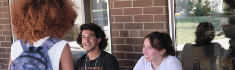 student at orientation table talking with other students