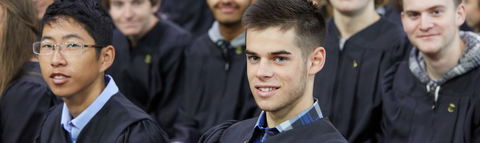 students seated at convocation smiling