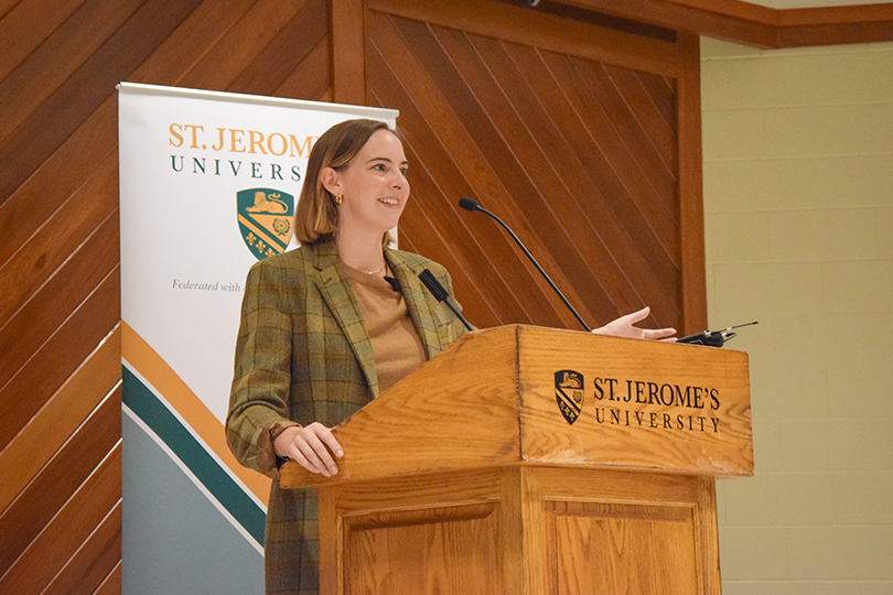 Colleen Dulle speaking to the audience from the podium at St. Jerome's University Chapel