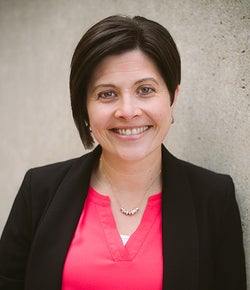 Michelle Watson smiling in a pink blouse and a black blazer
