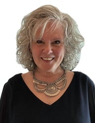 Dr. Rosemarie Burton Spohn smiles in front of a white background