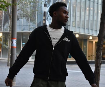 Shaun Annin-Bonsu posing in front of a University of Waterloo building