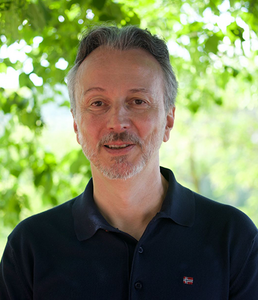 Yuri Sangalli smiles in front of a background of out of focus trees